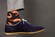 Shrimp patterned black cotton crew socks worn with brown leather shoes and dark pants on white background